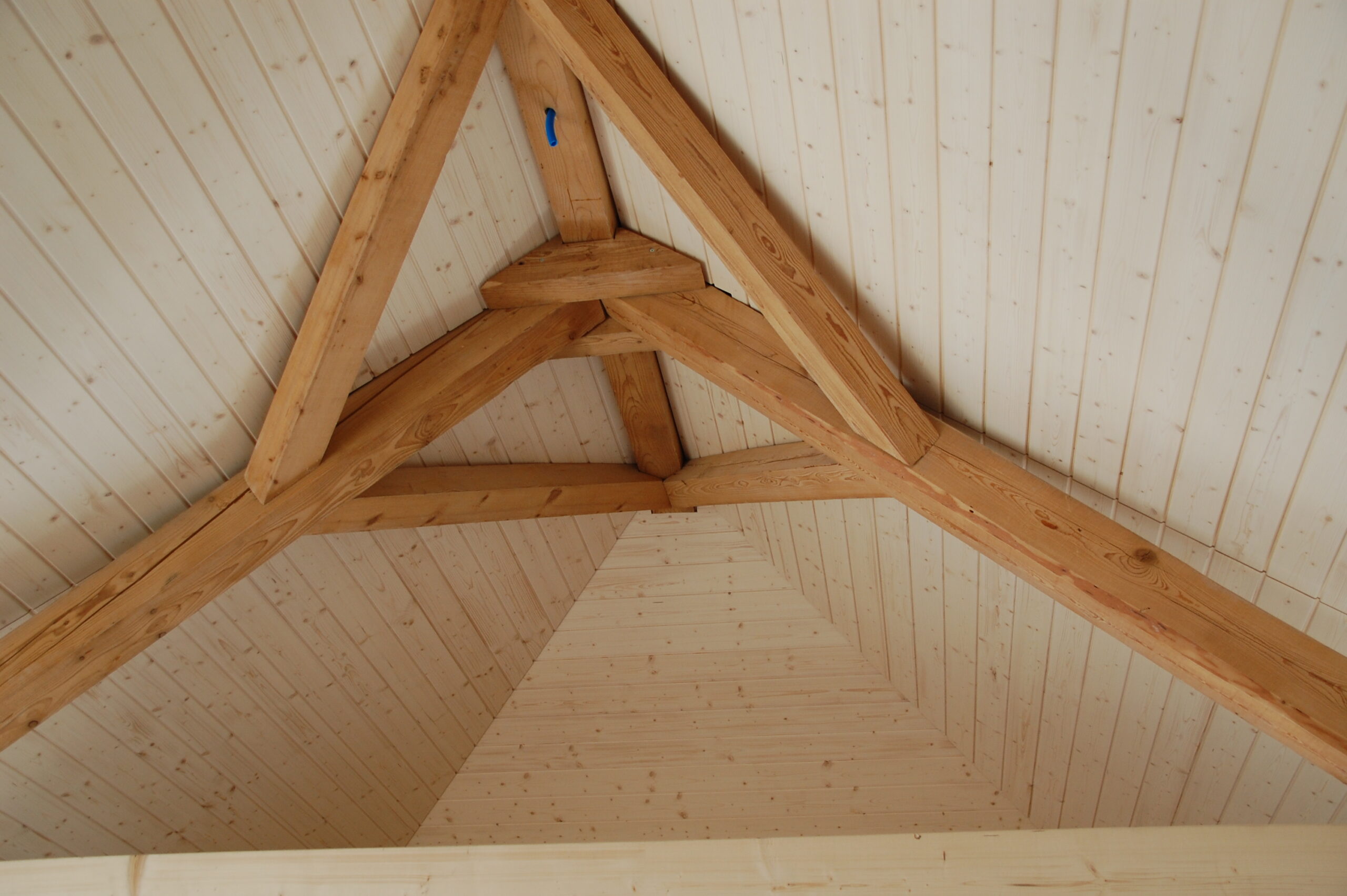 DSC_0073 Holzdachkonstruktion mit sichtbaren Balken und naturbelassenem Holz, modern und rustikal im Stil einer Holzhütte.